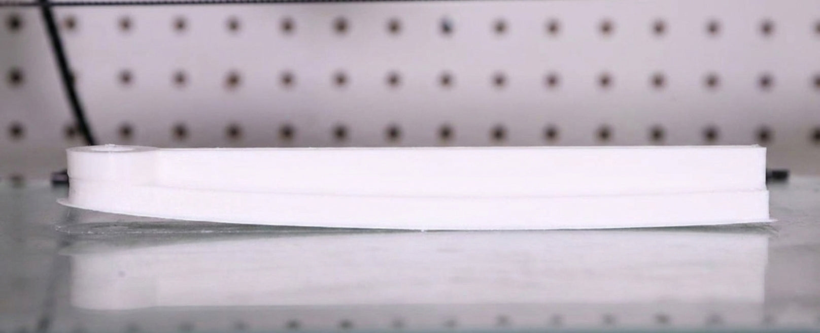 Example of warping in 3D printing where print corners lift off the build plate